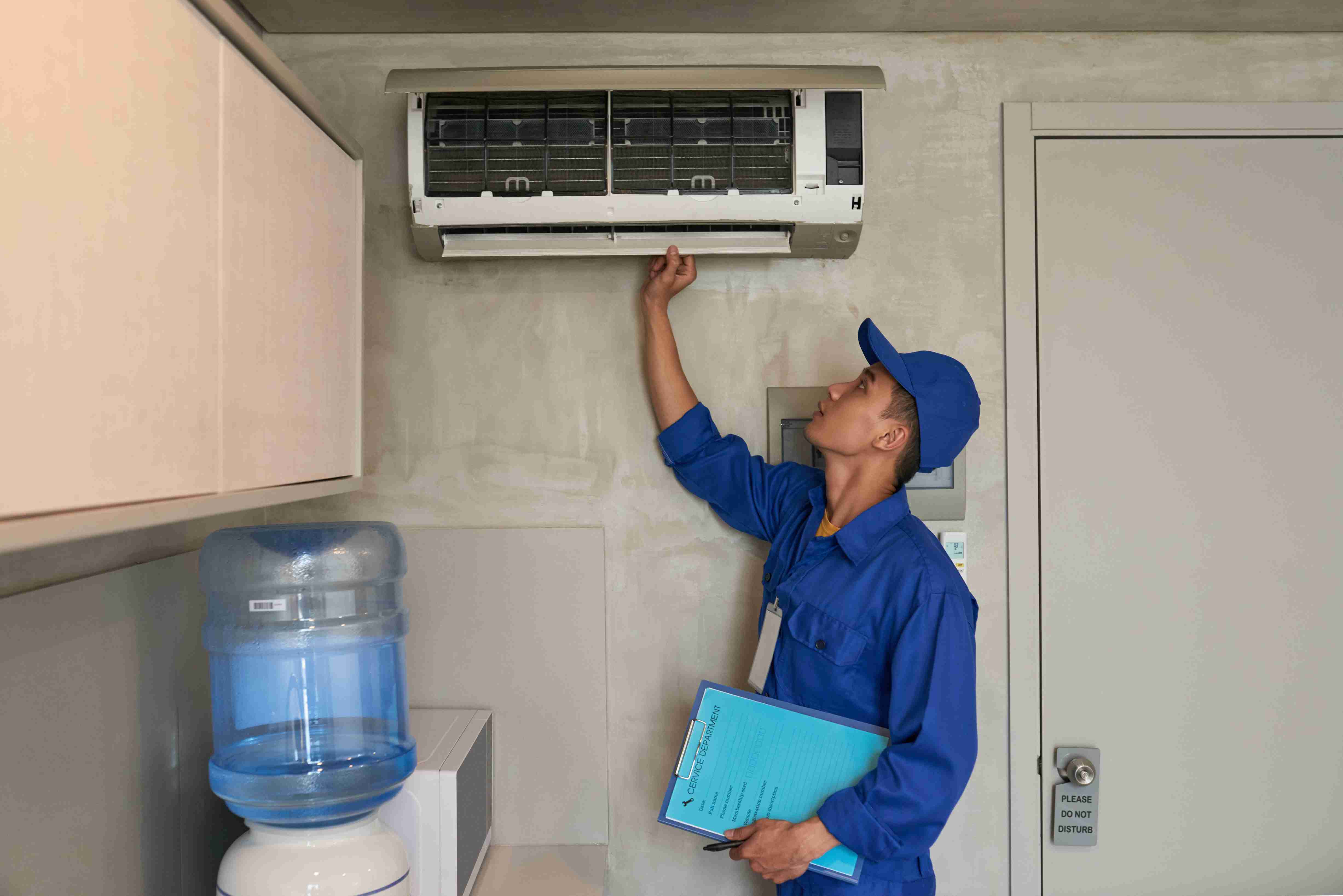 Technicien effectuant l'entretien d'une climatisation